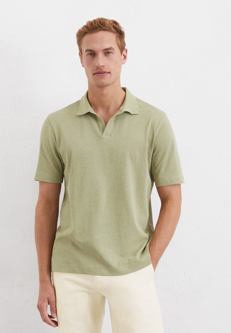 Polo à manches courtes de couleur olive avec col, fabriqué en tissu doux, doté d'une patte de boutonnage à trois boutons et d'une coupe décontractée.