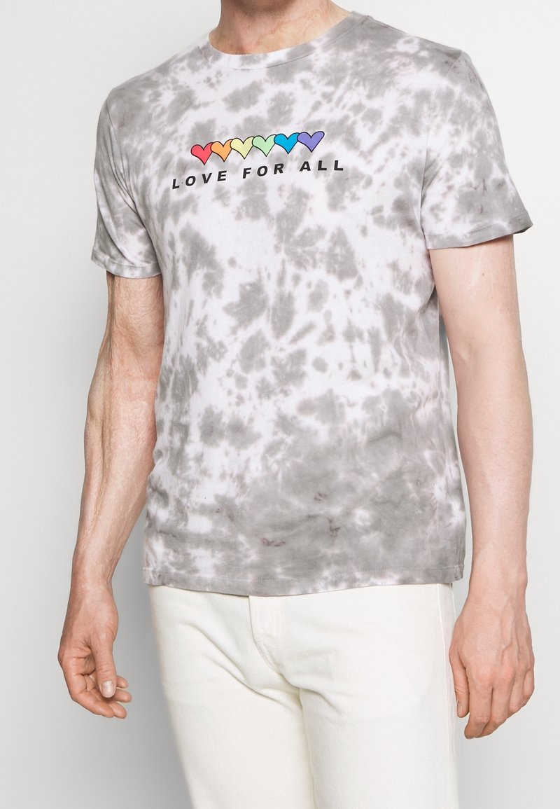 T-shirt gris à effet tie-dye avec manches courtes, arborant un cœur coloré et le texte "LOVE FOR ALL" en noir sur la poitrine.