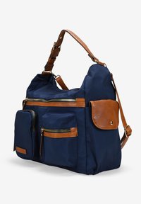 Bolsa de tela azul marino con detalles en cuero marrón, que cuenta con múltiples bolsillos con cremallera y una correa desmontable, mostrando un diseño práctico.