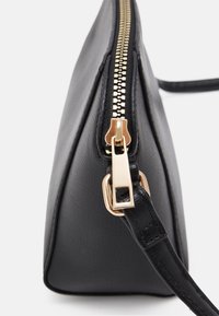 Borsa a tracolla nera in materiale sintetico con finitura texturizzata, dotata di zip e hardware in tonalità oro. Il design è angolare con un profilo sottile.