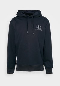 Marinblå hoodie med dragsko, framsidig känguruficka och broderad logotyp på bröstet. Tillverkad av mjuk, texturerad tyg med ribbad mudd.