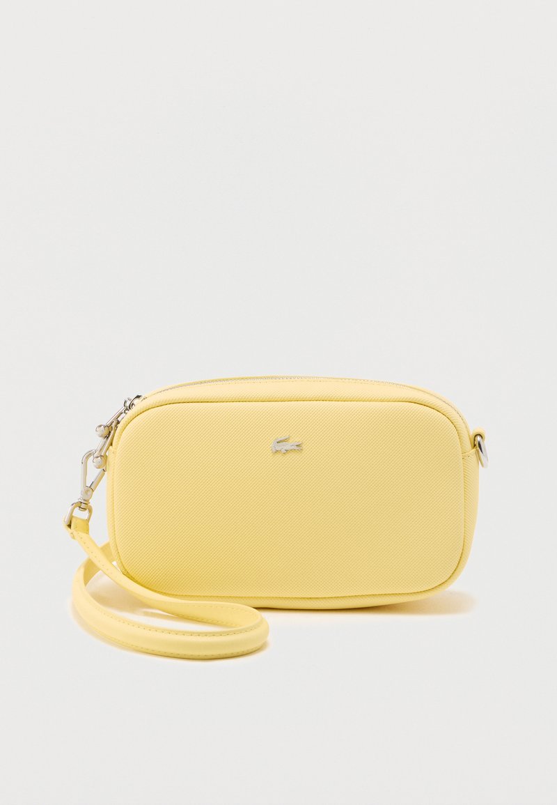 Gul tekstureret skuldertaske med en rektangulær form, sølvfarvet hardware og en tynd rem. Har en lille mærkelogo på forsiden.