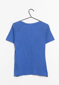 Modré tričko s krátkým rukávem a kulatým výstřihem. Vyrobeno z měkké tkaniny s jemnou texturou. Má raglánové rukávy a uvolněný střih.