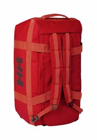 Mochila rectangular roja con correas acolchadas para los hombros, correas de compresión laterales y el logo negro "HH" en el panel lateral.