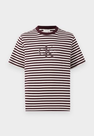 Striped T-shirt in burgundy and cream, featuring a crew neck and short sleeves. Displays "Calvin Klein" logo in the center. Soft fabric texture.
