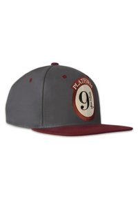 Graue Snapback-Cap mit einem kastanienbraunen Schirm, ausgestattet mit einem runden, gestickten Aufnäher mit "Platform 9¾" in Weiß und Braun.