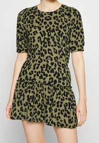 Vestido de estampado de leopardo en verde oliva y negro, con mangas cortas, cintura fruncida, bajo de volantes en capas, hecho de un tejido texturizado.