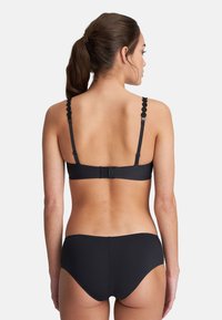 Black bikini set with scalloped straps, adjustable back closure, and smooth texture. Minimalist design with solid color throughout.