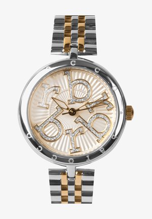 Apvalus laikrodis su auksiniu ir sidabriniu nerūdijančio plieno dirželiu. Kremiškas ciferblatas turi didelius sidabrinius ženklus ir žvilgančius akcentus. Išsamiai tekstūruota fono.