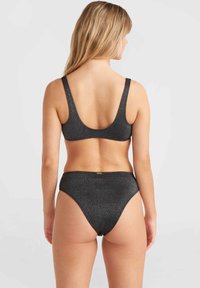 Čierny bikiny set s textúrovanou, lesklou tkaninou. Vrchná časť má široký výstrih na chrbte a vysoké nohavičky poskytujú plné pokrytie.