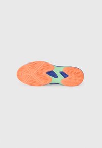Semelle de chaussure présentant une combinaison vibrante de caoutchouc orange et vert avec un motif de tressage en zigzag et des accents bleus le long des bords.