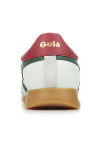 Sneaker bianca con toppa rossa sul tallone, strisce verdi e logo dorato "Gola". Presenta un retro testurizzato e una suola in gomma marrone chiaro.