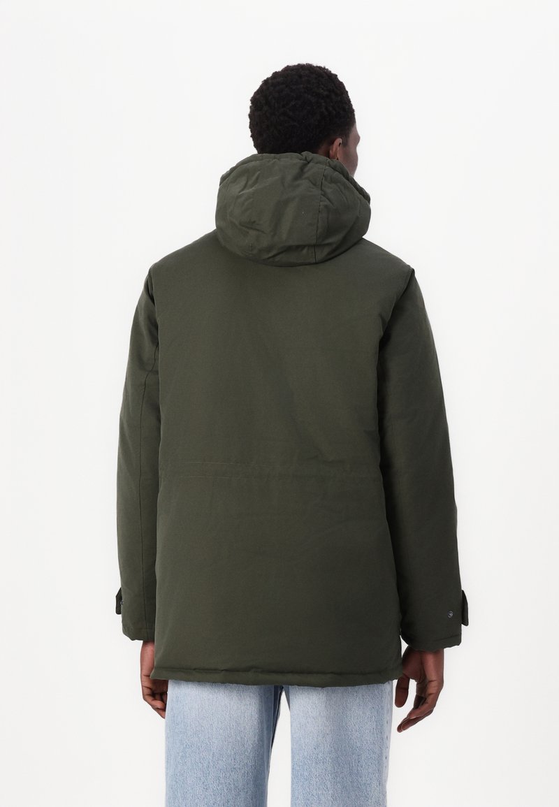 Doudoune verte avec capuche, présentant une texture lisse et des manches longues. Le dos a une coupe droite avec une couture visible.