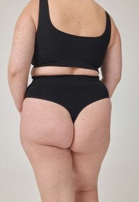 Czarny dwuczęściowy komplet składający się z crop topu z szerokimi ramiączkami oraz majtek z wysokim stanem. Gładka faktura, minimalistyczny design, brak widocznych wzorów.