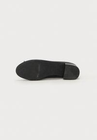Sola di scarpa nera con superficie liscia e piatta e un motivo di presa testurizzato. Forma arrotondata con un leggero rialzo nel tallone. Materiale in gomma durevole.