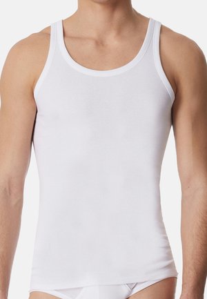 Männlicher Oberkörper, bekleidet mit einem enganliegenden weißen ärmellosen Tanktop und weißer Unterwäsche, dargestellt von Hals bis oberer Oberschenkel auf einem schlichten Hintergrund.