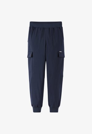 Marynarskie niebieskie spodnie jogger typu cargo z elastycznym pasem, bocznymi kieszeniami z klapkami i ściągaczami przy kostkach na białym tle.