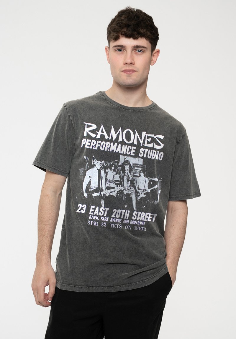 Gray graphic t-shirt featuring the "Ramones" logo and performance studio details in white, with a relaxed fit and short sleeves.