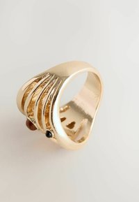 Guldtonet ring med bølgede bånd, der har to ædelstene: en sort og en brun. Glat overflade, afrundet inderside og åbent design.