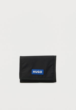 Black nylon wallet with a fold-over design, featuring a blue rectangular "HUGO" logo patch on the front and visible stitching accents.