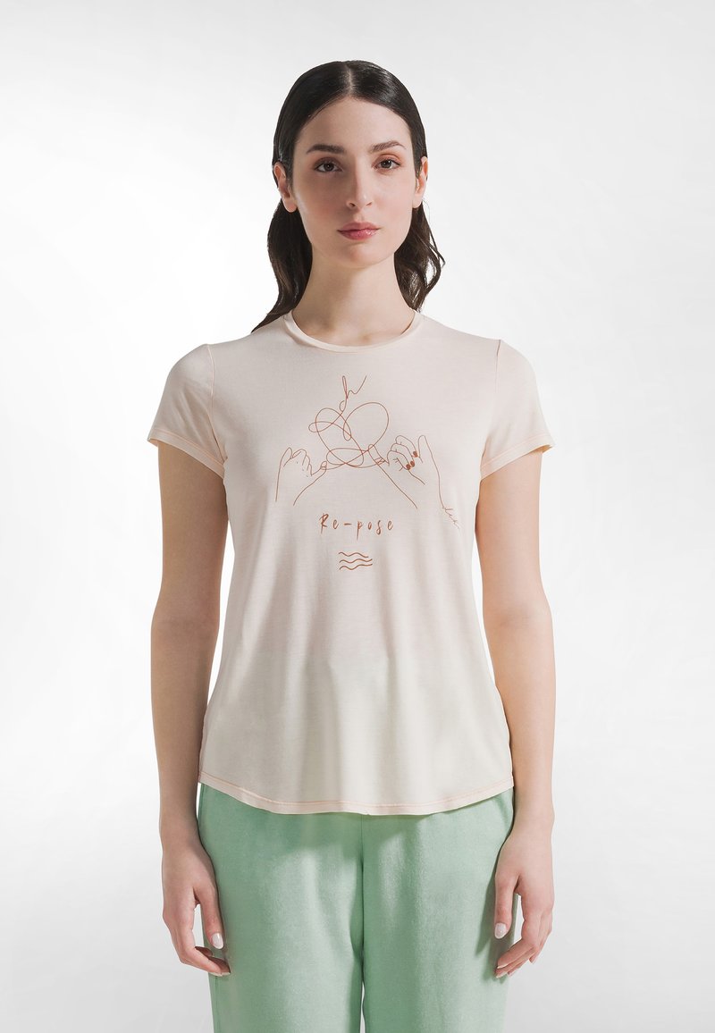 Jasnoróżowa koszulka z prostym szkicem dłoni i słowem „Re-pose” napisanym kursywą, wykonana z miękkiego, oddychającego materiału.