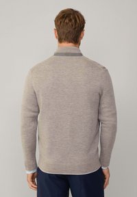 Pull en tricot gris clair avec des manches longues et un ourlet arrondi. Comprend un col contrastant et des poignets côtelés. Design décontracté avec une finition texturée.