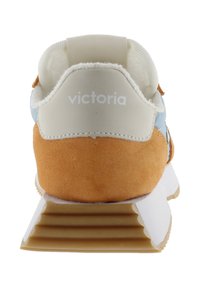 Baskets avec un talon en daim marron, tige en tissu bleu clair et une semelle en caoutchouc blanche présentant un design rainuré. Logo "Victoria" sur le talon.