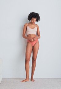 Világos rózsaszín bordázott bralette és őszibarack színű magas derekú alsó. Sima textúra, egyszerű design, állítható pántok, egyszínű színek minta nélkül.