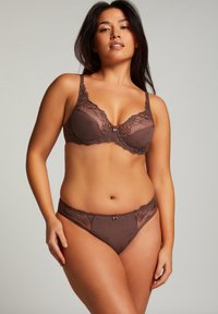 Bruin lingerie set met een kanten beha met bloemenborduurwerk en een bijpassende slip; zacht stof, ingewikkelde texturen en delicate accenten.