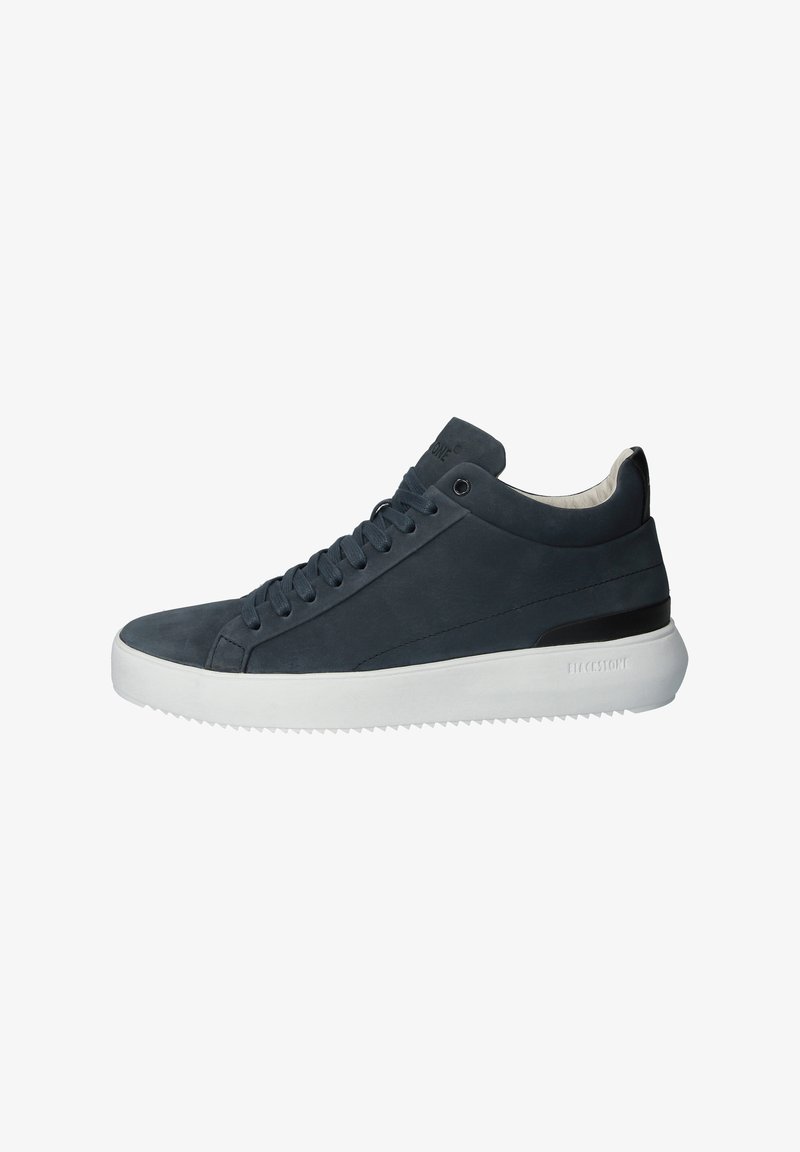 Baskets en daim gris foncé avec semelle en caoutchouc blanche, bout arrondi et lacets ton sur ton. Présente un accent noir au talon et un logo sur la languette.