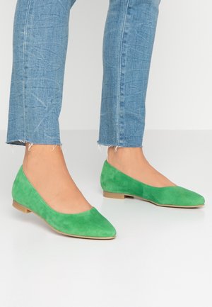 Zielone zamszowe baleriny z wąskim czubkiem i małym, płaskim obcasem. Uzupełnione gładkim wykończeniem, w połączeniu z jasnoniebieskimi, krótkimi dżinsami.