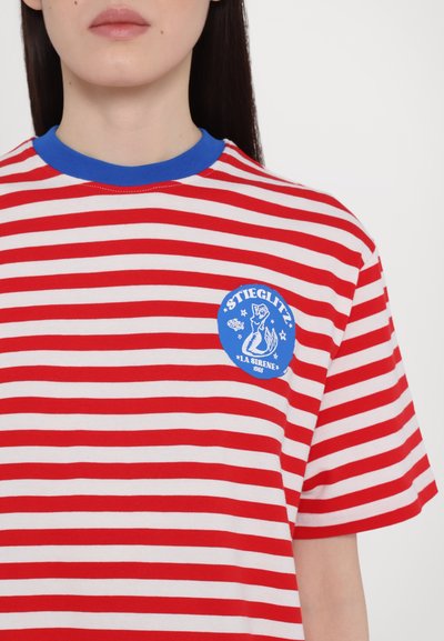 Red and white striped t-shirt with blue collar. Features a blue circular logo with text and graphic of a mermaid on the chest. Cotton material.