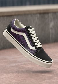 Sorte og lilla leopardmønstret sneaker med hvite detaljer, flate snøringer og gummisåle. Har et moderne design med kontrasterende teksturer.