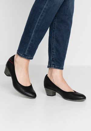 Zapatos de tacón de cuero negro con un diseño de punta redonda, que cuentan con un tacón texturizado gris y un sutil acento rojo en el lateral.