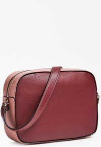 Punainen ja vaaleanpunainen nahkainen olkalaukku, jossa on sileä pinta, suorakulmainen muoto, vetoketjullinen suljenta ja säädettävä hihna.