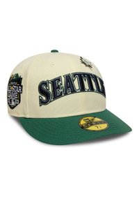 Gorra de béisbol crema con visera verde. Presenta "SEATTLE" bordado en azul marino, con un parche del Juego de Estrellas de Seattle y un acento de estrella.