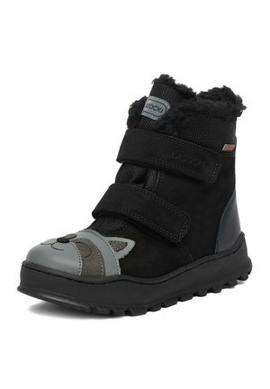 Bota de invierno negra para niños con forro mullido, dos tiras de velcro y un diseño de cara de animal gris en la puntera.