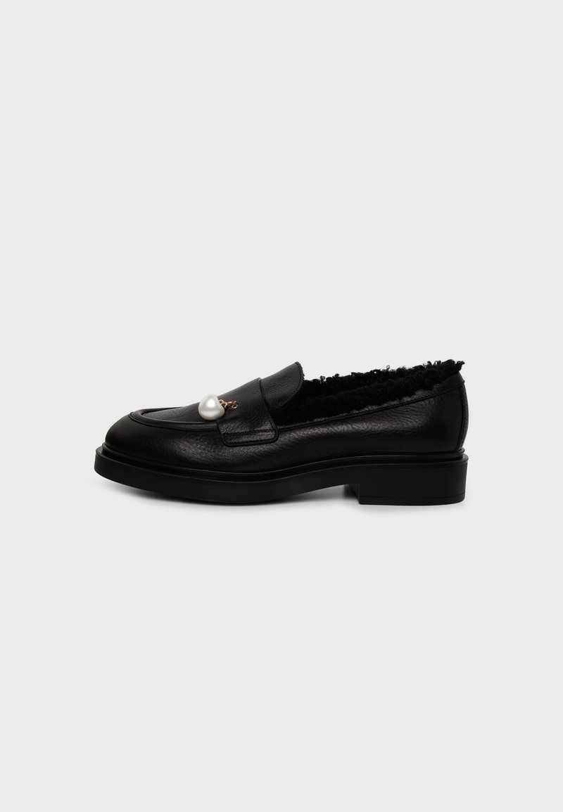 Mocassin en cuir noir doublé de fourrure avec une perle décorative unique sur la tige, semelle plate et petit talon.