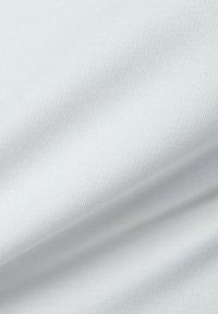 Close-up of smooth, light gray fabric with a fine weave texture and subtle diagonal folds.