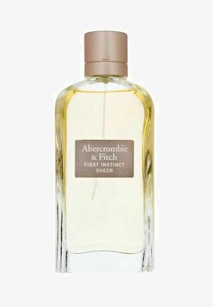 Gennemsigtig glas parfume flaske med rund form og en lys guldmetallåg. Har en rektangulær etiket med teksten "Abercrombie & Fitch FIRST INSTINCT SHEER."