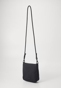Sort crossbody taske lavet af blødt stof, med en rektangulær form, justerbar skulderrem og en lynlåslukning med to metalaccenter.