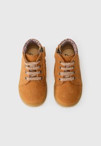 Braune Lederkinderschuhe mit strukturiertem Obermaterial, runder Zehenform und geflochtenen Schnürsenkeln; gepolsterter Kragen aus einem gemusterten Stoff.