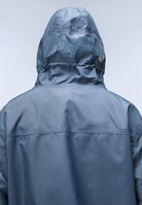 Water-resistant blue jacket with a hood, featuring a smooth texture and a subtle printed logo on the back. Simple design and clean lines.