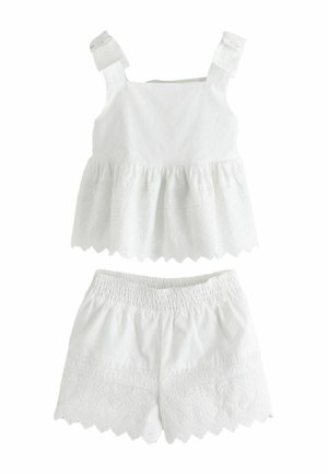 White sleeveless top with ruffled hem and scalloped embroidered shorts, both made of lightweight fabric with eyelet detailing.