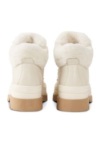 Kremowe skórzane botki z miękkim, białym sztucznym futerkiem przy kołnierzu, o fakturowanej powierzchni i jasnobrązowych gumowych podeszwach. Casualowy design z minimalnymi zdobieniami.