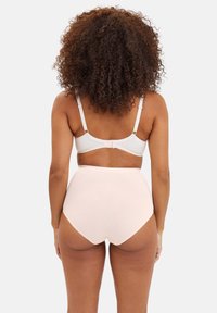 Culottes taille haute rose clair en tissu doux, avec une texture lisse et un design minimaliste, assorties à un soutien-gorge blanc orné de dentelle.
