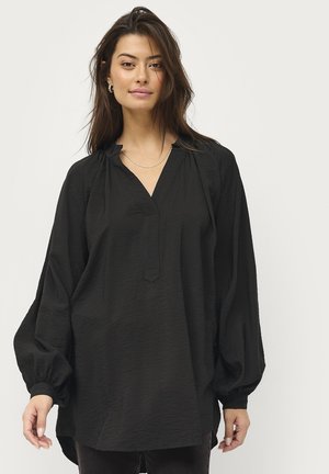 Blusa nera a maniche lunghe con scollatura a V, spalle arricciate e polsini elasticizzati. Tessuto testurizzato con vestibilità morbida e orlo leggermente curvato.