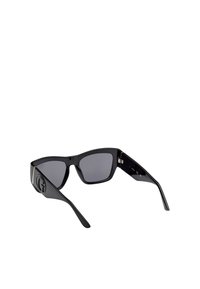 Sorte solbriller med en blank finish, vinklede stel, mørke linser og en fremtrædende logopolitik på stængerne. Har sølvdetaljer.