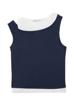 Canotta corta senza maniche blu navy indossata sopra una maglietta bianca a maniche corte con scollo rotondo.