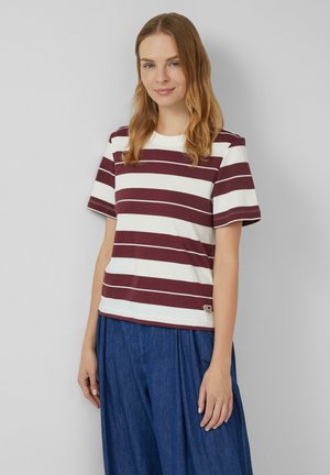 Gestreepte katoenen t-shirt in kastanjebruin en wit, ronde halslijn, korte mouwen, met een logo-detail op de zoom. Gecombineerd met losse blauwe broeken.